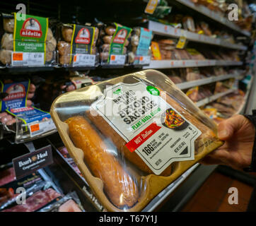 Un client choisit un paquet de viande au-delà au-delà d'une marque de saucisses refroidisseur dans un supermarché de New York le lundi 22 avril 2019. Les protéines à base de plantes start-up au-delà de la viande a déposée pour une offre publique initiale et s'attend à ce que le prix de l'action d'être entre $19 et $21 la valorisation de l'entreprise de plus de 1 milliards de dollars, bien dans l'oeunicornâ€ royaume. (Â© Richard B. Levine) Banque D'Images