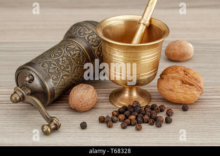 Spice cuisine moulin manuel et bronze muller grinder sur fond de bois Banque D'Images