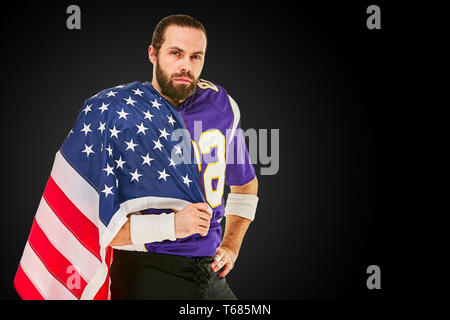 Joueur de football américain avec l'uniforme et drapeau américain fier de son pays, sur un fond blanc. Banque D'Images