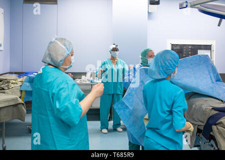 Chirurgie, Médecine et personnes concept - groupe des chirurgiens en salle d'opération à parler de l'hôpital et la préparation à l'opération Banque D'Images