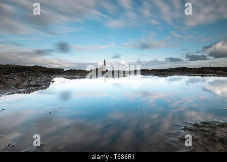 Photos à longue exposition de St Mary's phare au nord de Newcastle, UK, reflétée dans une piscine dans les rochers sur la plage Banque D'Images