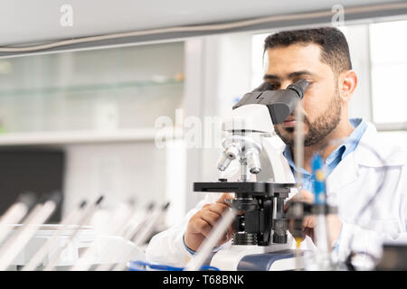 Chercheur scientifique à l'aide de microscope, Arabe Banque D'Images