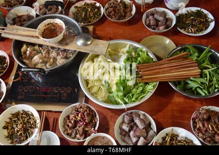 Chinois traditionnel repas comprend de nombreuses planches avec différents delicius et aliments colorés. La nourriture faite maison dans la province du Guizhou en Chine. Banque D'Images