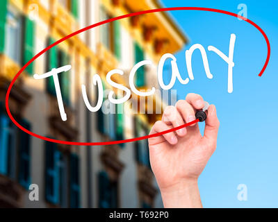 Man main écrit toscane avec un marqueur noir sur l'écran visuel. Banque D'Images