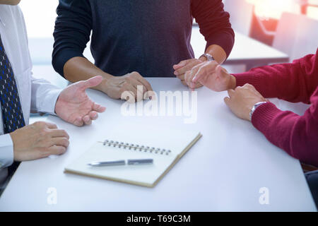 Close-up de personnes sur la discussion ou de communiquer tout en restant assis à la table pour résoudre des problèmes et prendre des décisions avec leurs collègues. Banque D'Images