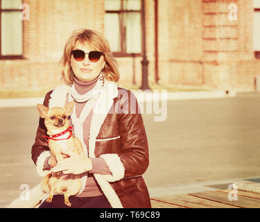 Jolie femme et son chien chihuahua sur fond Nature. Banque D'Images