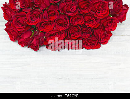 Bouquet de fleurs colorées de roses rouges sur fond de bois blanc. Banque D'Images