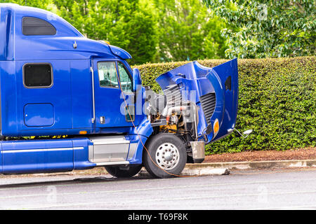 Broken-américain de transport de marchandises de qualité industrielle gros camion bleu semi truck tracteur à ouvrir le capot se dresse sur l'arrêt de camion en attente de stationnement Banque D'Images