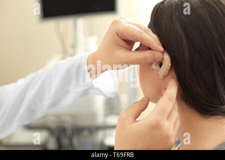 Oto-rhino-laryngologiste mettre dans l'oreille de la femme à l'intérieur Banque D'Images