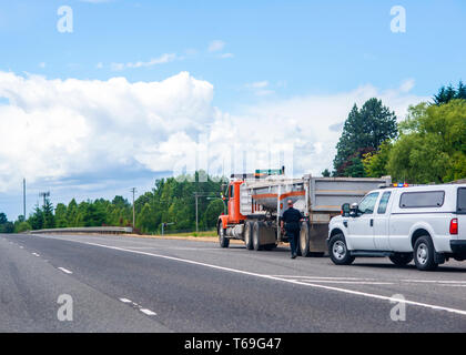 Un policier en uniforme s'arrêta un gros camion semi truck pour vérifier un chauffeur de camion et l'inspection d'un chariot pointe et des approches pour le chariot sur le sid Banque D'Images