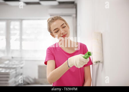 Mur peinture décorateur femelle avec rouleau à l'intérieur Banque D'Images