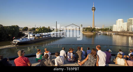 Les gens sur une terrasse de restaurant avec vue sur la tour du Rhin, Düsseldorf, Allemagne Banque D'Images