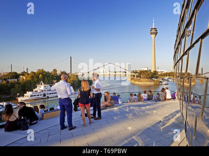 Les gens sur une terrasse de restaurant avec vue sur la tour du Rhin, Düsseldorf, Allemagne Banque D'Images