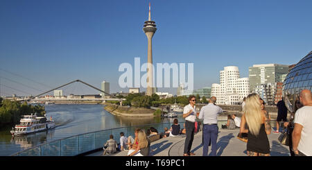 Les gens sur une terrasse de restaurant avec vue sur la tour du Rhin, Düsseldorf, Allemagne Banque D'Images