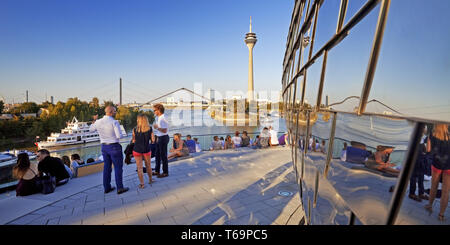 Les gens sur une terrasse de restaurant avec vue sur la tour du Rhin, Düsseldorf, Allemagne Banque D'Images