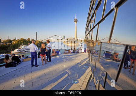 Les gens sur une terrasse de restaurant avec vue sur la tour du Rhin, Düsseldorf, Allemagne Banque D'Images