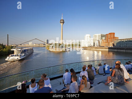 Les gens sur une terrasse de restaurant avec vue sur la tour du Rhin, Düsseldorf, Allemagne Banque D'Images