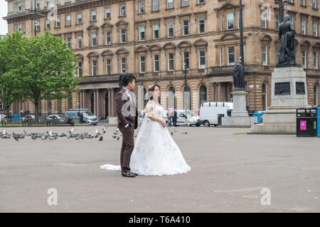 Glasgow, Ecosse, Royaume-Uni. 30 avril, 2019. Météo britannique. Une femme et un homme ayant pris des photographies de mariage sur un après-midi pluvieux d'intervalles de George Square. Credit : Skully/Alamy Live News Banque D'Images