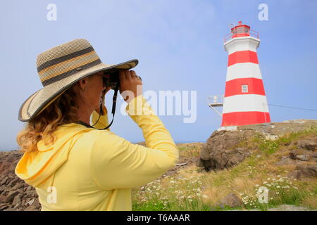 Une jeune femme à la recherche d'un phare avec des jumelles Banque D'Images