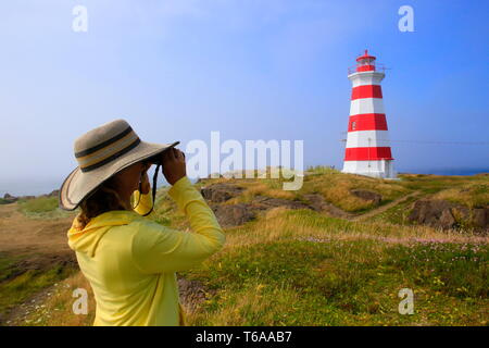 Une jeune femme à la recherche d'un phare avec des jumelles Banque D'Images