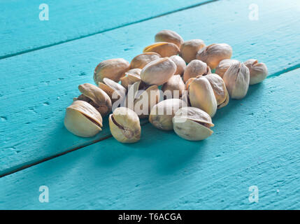 Les pistaches sur une table en bois couleur bleu. Banque D'Images