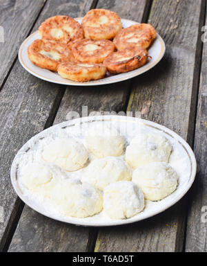 Traditionnellement, les matières premières russes et crêpes frites avec du fromage cottage. Crème glacée sur une table rustique en bois. Le processus de cuisson. Banque D'Images