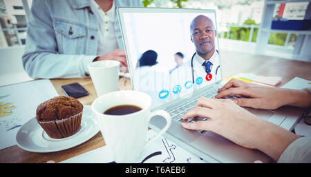 Image composite de jeunes et confiant médecin souriant en face de son équipe médicale Banque D'Images