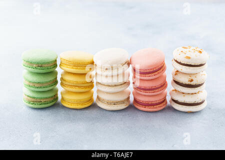 Des piles de macarons colorés avec différents matériaux dans une rangée. Banque D'Images