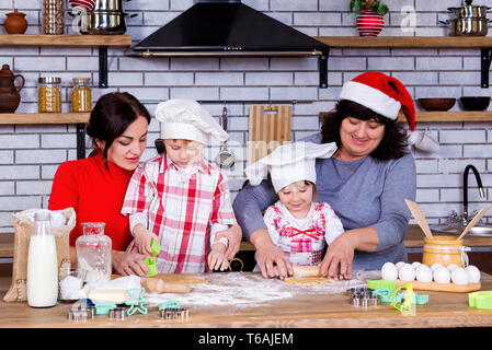 Cuisine familiale heureux ensemble dans la cuisine d'épices de Noël sur la table des fêtes. Banque D'Images