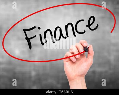 Man main écrit Finances avec marqueur noir sur l'écran visuel. Banque D'Images