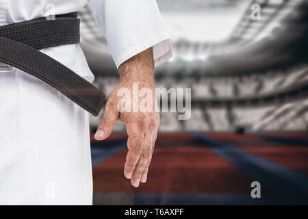 Image composite de close-up de ceinture noire de karaté sur l'uniforme blanc Banque D'Images