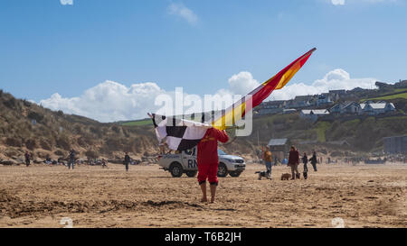 MAWGAN PORTH, ANGLETERRE - 16 avril 2019 : sauveteurs et les touristes dans une scène de plage typique de Mawgan Porth beach, North Cornwall, England, UK Banque D'Images