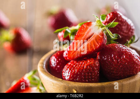 Laver les fraises juteuses dans bol en bois sur la table de cuisine Banque D'Images