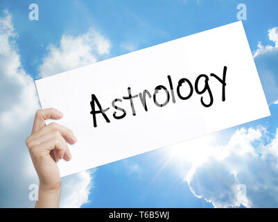 Signe astrologie sur du papier blanc. Tenir la main de l'homme papier avec texte. Isolé sur fond de ciel Banque D'Images