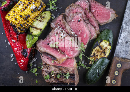 Barbecue New York strip steak avec des légumes sur la vieille feuille de métal Banque D'Images