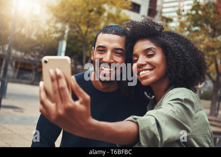 Smiling young couple prenant en selfies city park Banque D'Images