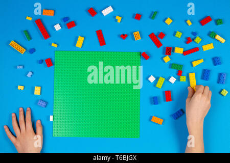 Les mains des enfants jouer avec des blocs Lego colorés sur la table Banque D'Images