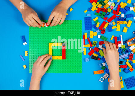 Les mains des enfants jouer avec des blocs Lego colorés sur la table Banque D'Images