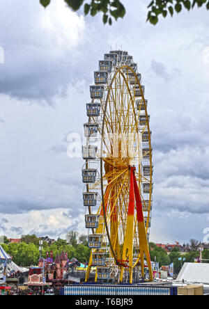 MUNICH, ALLEMAGNE - grande roue de style bavarois avec des stands lors du festival du printemps de Theresienwiese à Munich, parc d'attractions avec de nombreux Banque D'Images