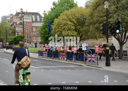 Manifestants devant le Parlement reste Brexit, Londres UK 29 avril 2019. Au premier plan, un homme monté sur un tilleul location vélo à assistance électrique E Banque D'Images