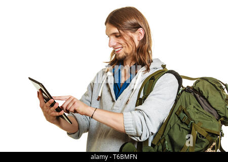 L'homme à l'aide d'ordinateur pc Backpacker tablet parcourt la navigation sur internet. Les jeunes de randonnée randonneur. La technologie moderne. Banque D'Images