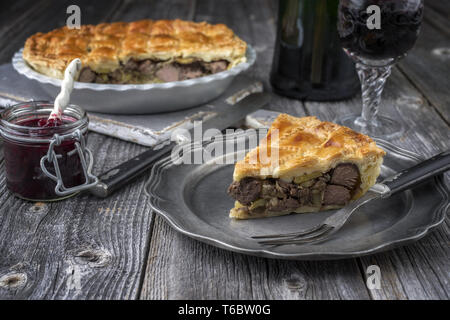 Tarte rustique du gibier avec relish de canneberges comme close-up sur une plaque Banque D'Images