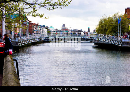 Les personnes qui traversent Ha'penny Bridge sur la rivière Liffey à Dublin, Irlande Banque D'Images