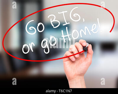 Man main écrit Go Big or go home avec marqueur noir sur l'écran visuel Banque D'Images