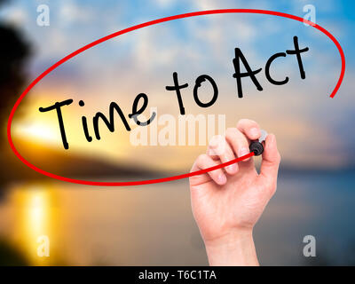 Man main écrit le temps d'agir avec marqueur noir sur l'écran visuel. Banque D'Images