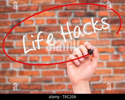 Man main écrit Life Hacks avec marqueur noir sur l'écran visuel Banque D'Images