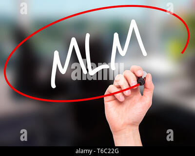 Man main écrit MLM (Multi-Level Marketing) avec marqueur noir sur l'écran visuel Banque D'Images