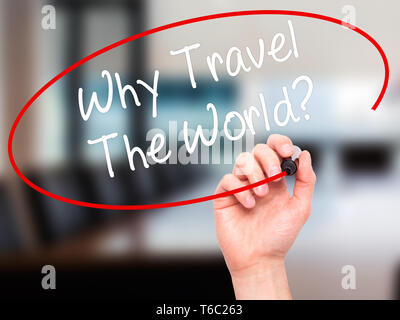 Man main écrit Pourquoi voyager dans le monde entier ? Avec marqueur noir sur l'écran visuel Banque D'Images