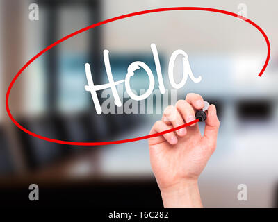 Man main écrit Hola (bonjour en espagnol) avec marqueur noir sur l'écran visuel Banque D'Images