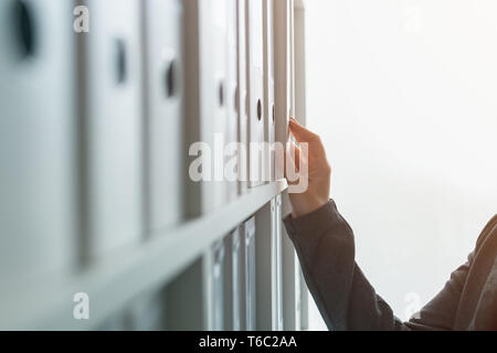 Businesswoman parcourant classeur documentation fichiers archives o l'étagère par bureau d'affaires, Close up of hand Banque D'Images